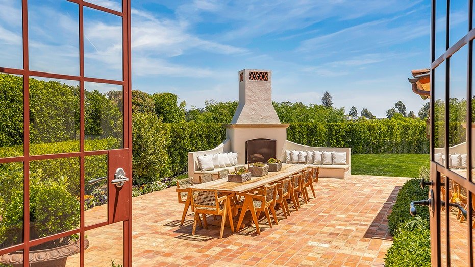 The backyard is characterized by an outdoor food area with a fireplace on firewood.