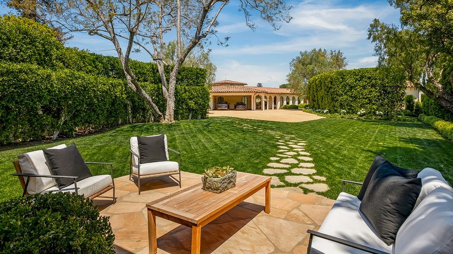 A seating area can be found a short distance from a garage.