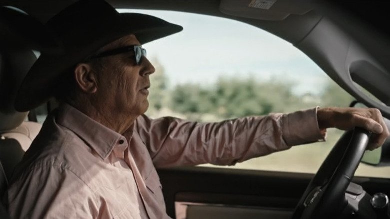 John Daton of Kevin Costner drives a car in Yellowston