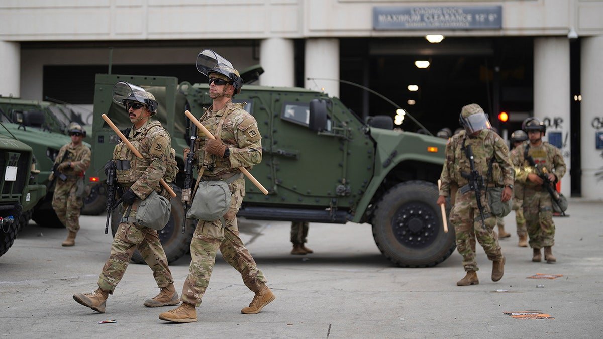 The American National Guard forces walk next to the car