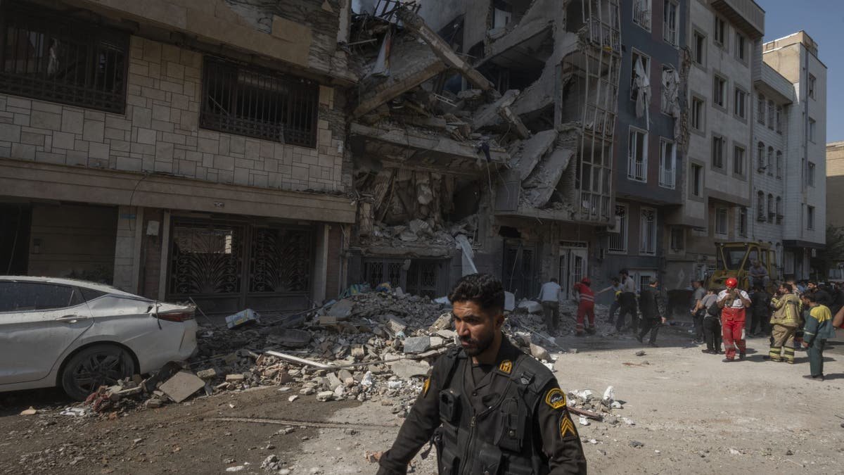 An Iranian policeman is running through an residential building destroyed in Israeli attacks in Tehran, Iran, on June 13, 2025. 