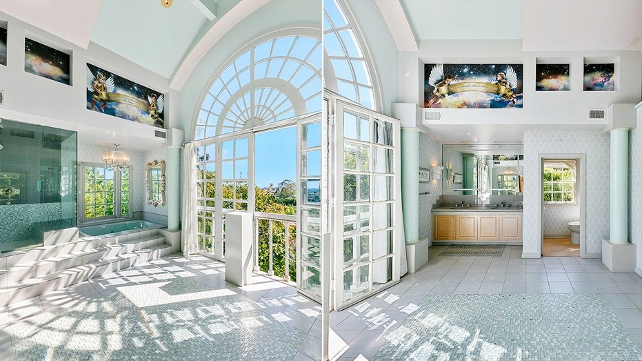 The inner bathroom features a large window with views of the city, as well as a bath and shower.