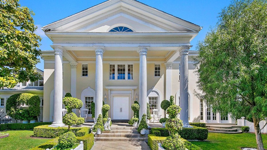 The road leads to a luxurious main house with Corinthian columns.