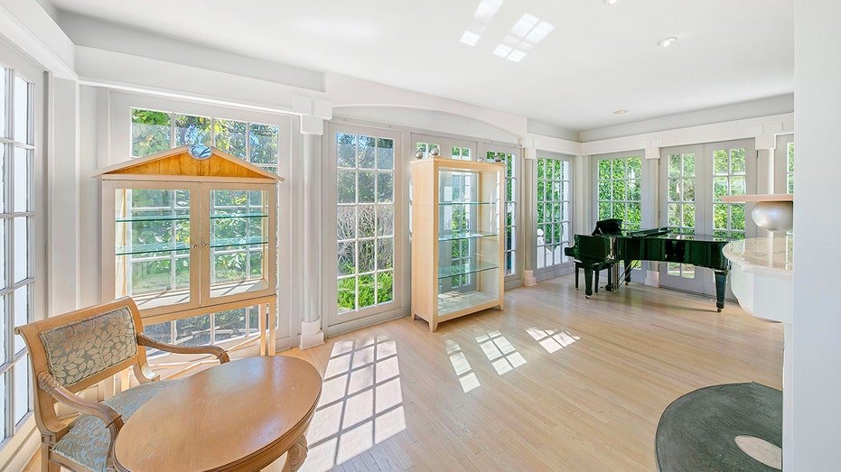 A piano and a small seating area can be found on the other side of the two -sided stove.