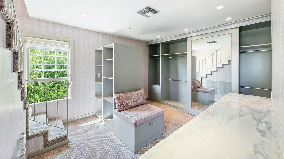 Walk-in Closet features built-in shelves and a pink rear shelves.