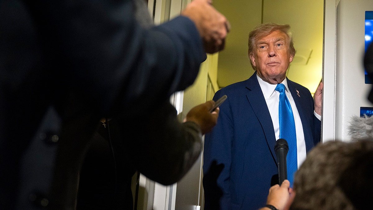 Trump listens to reporters on the Air Force