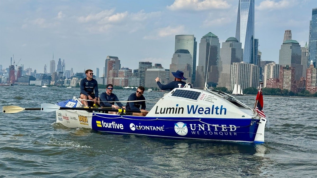 The rowing team of 4 men aboard their boat in New York Port