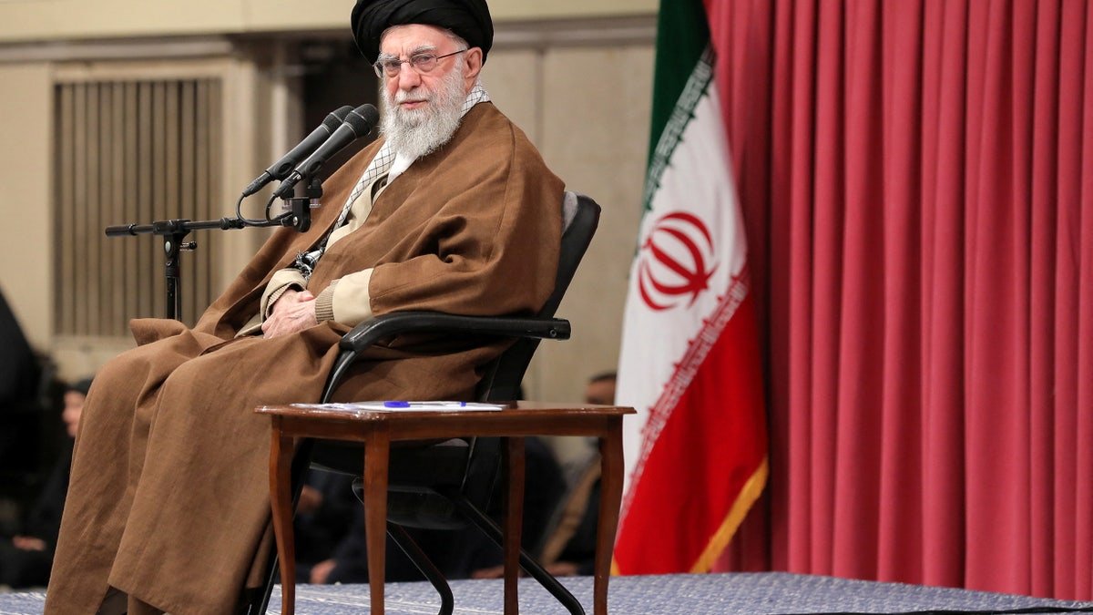 Glory to a chair, Iran's flag behind it