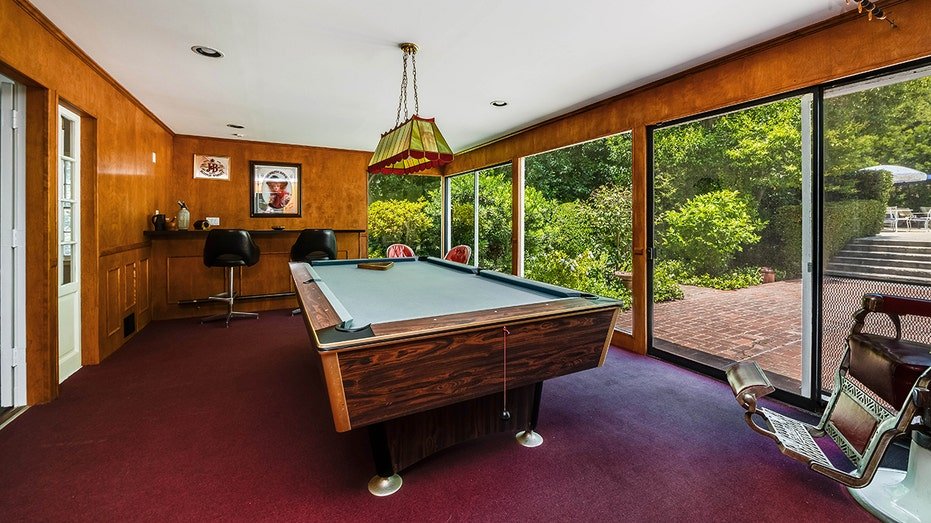The house also includes a game room with a billiard and bar table, with windows from floor to ceiling.