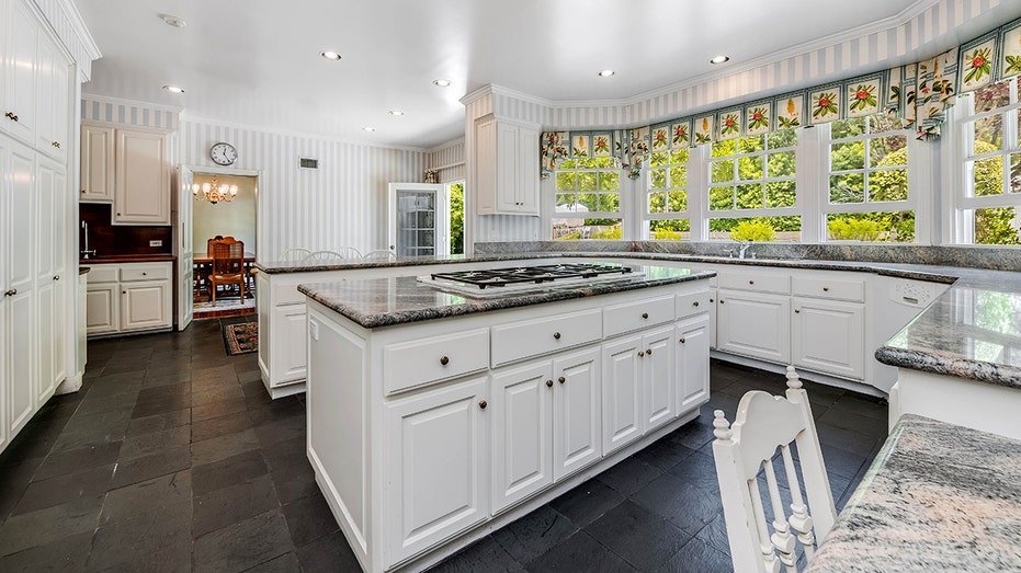 The kitchen features a central island and a window of windows.