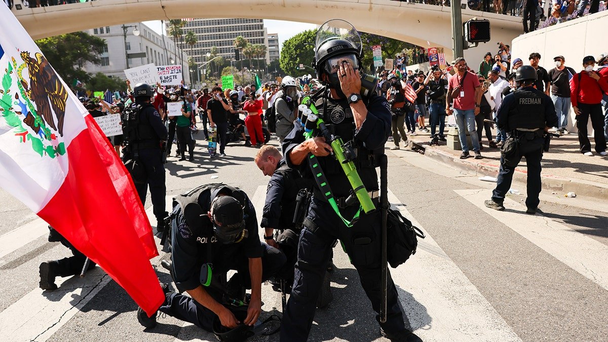 Police officers who arrest protesters in riots, the Mexican flag on the left in the frame