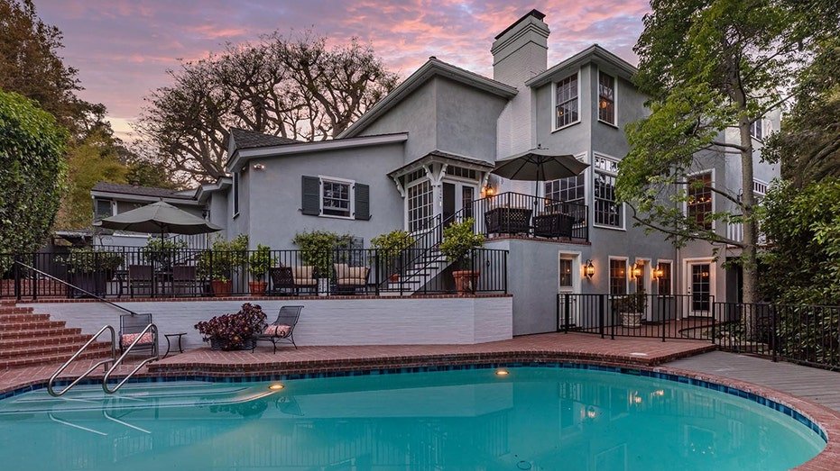 The backyard is characterized by large swimming swimming and multiple external living areas.