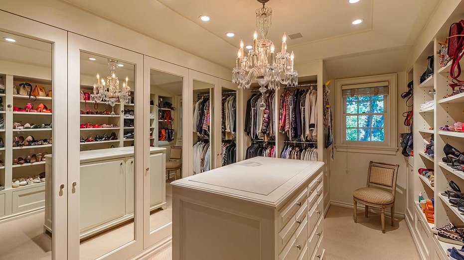 Walk-in Closet features a middle island as well as built-in shelves to store shoes.