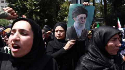 The Iranians hold a picture of the Iranian supreme leader Ayatollah Ali Khounai during an anti -Israel gathering in Tehran