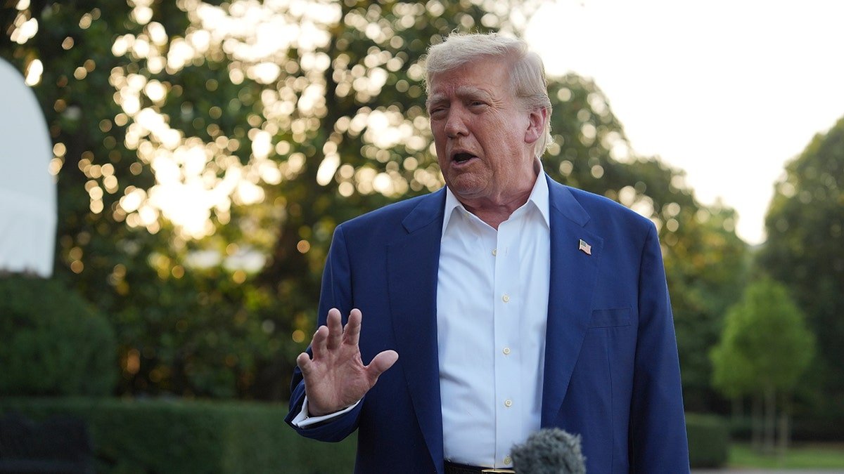 President Donald Trump speaks with journalists in the southern grass of the White House.