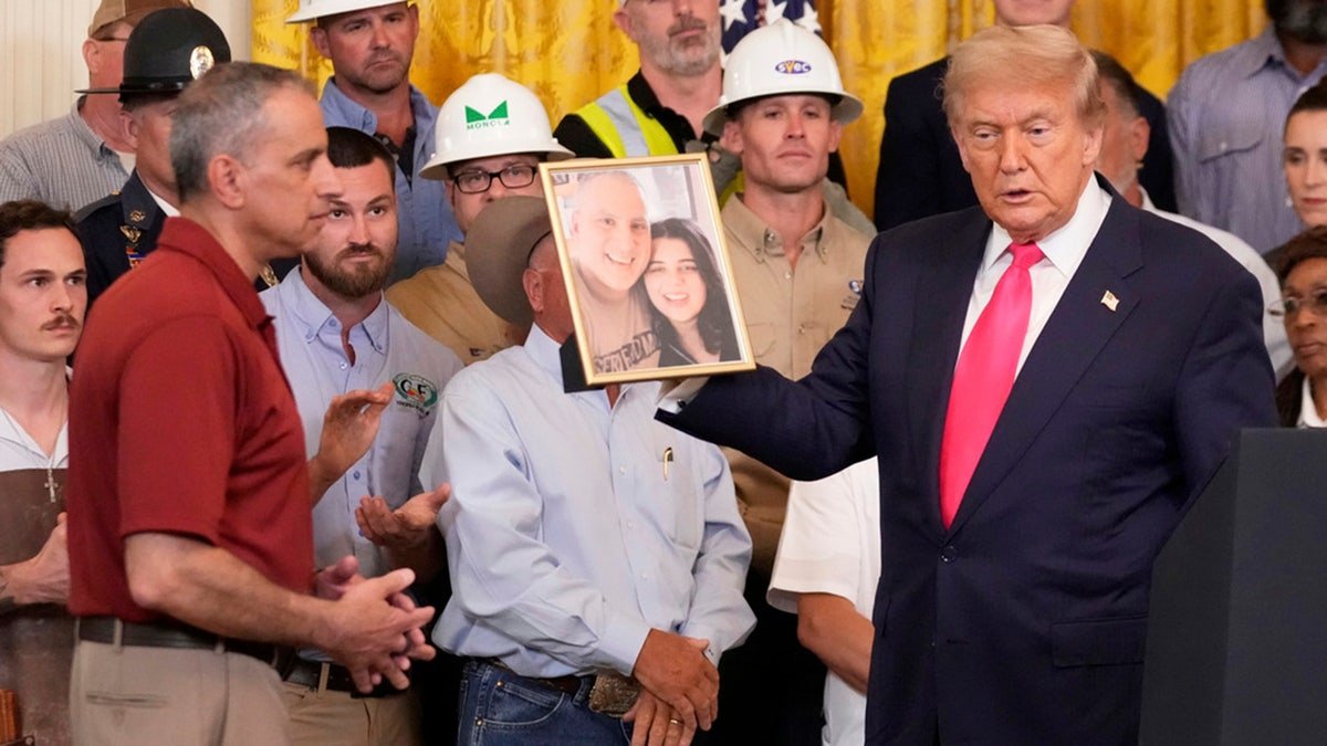 President Donald Trump holds a picture of Katie Ibrahim.