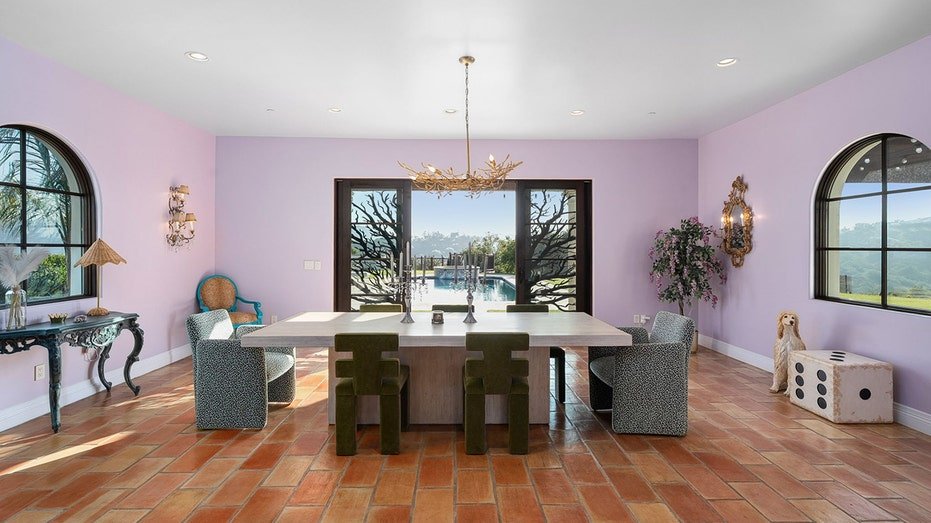 The dining room features purple walls and decorative doors that lead to the backyard.