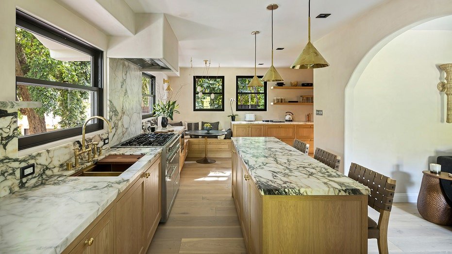 The kitchen features a central island for dining, built -in shelves, and breakfast.