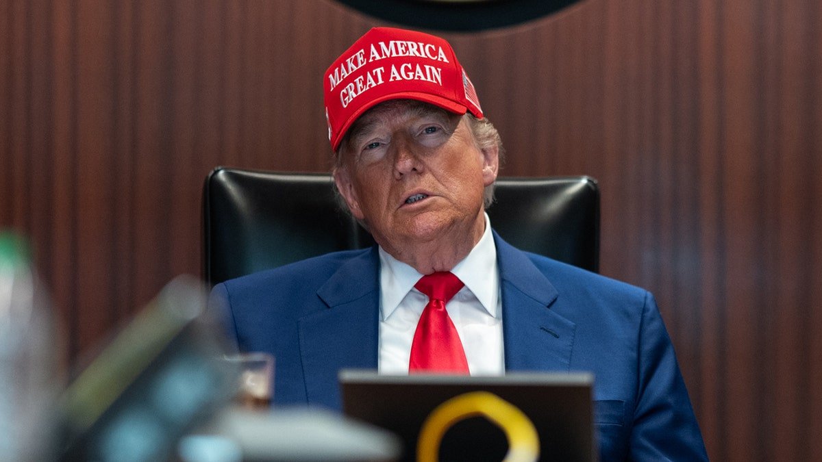Trump in the position room with the Maga hat