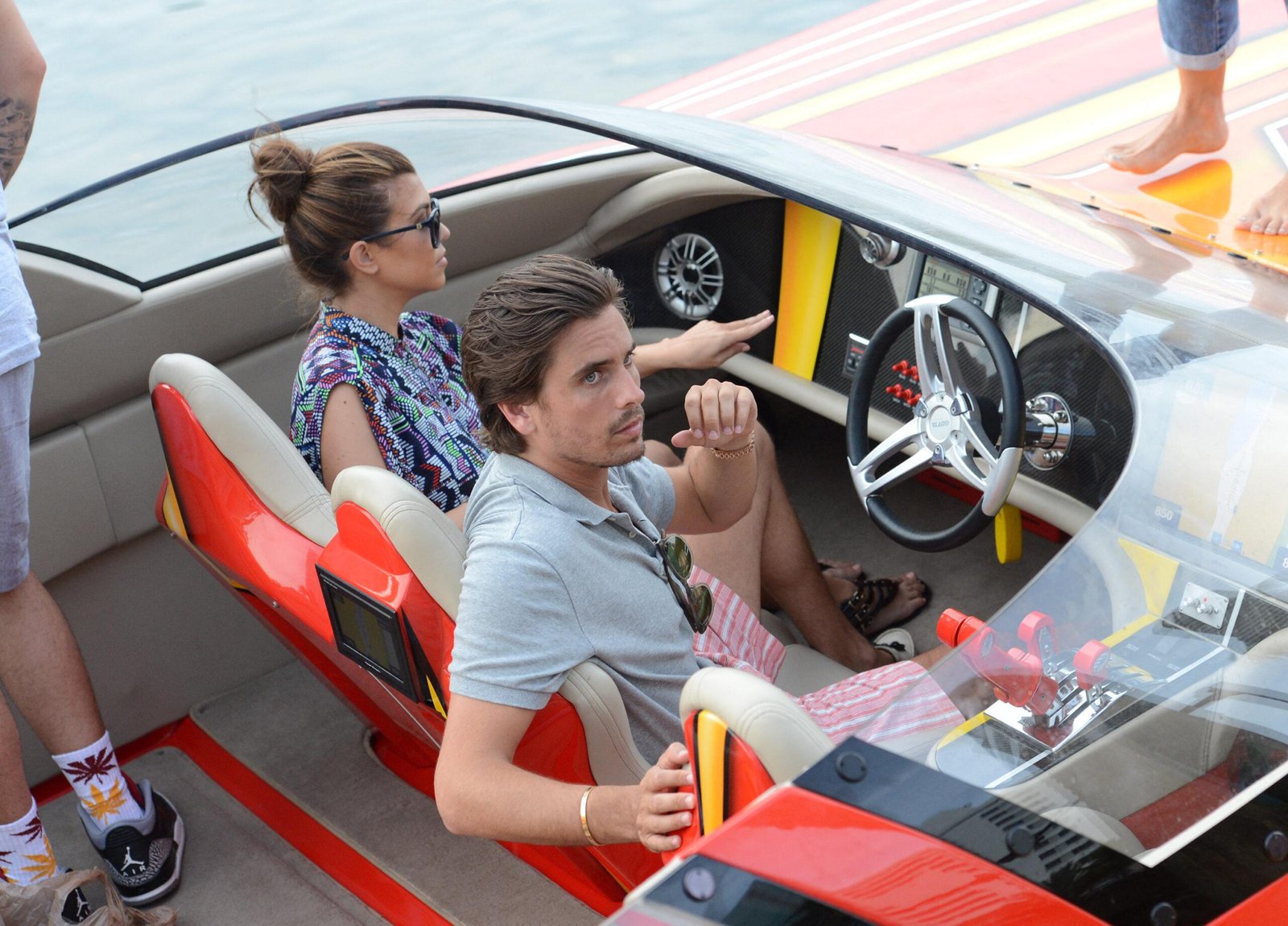 Kourtney Kardashian TV and his friend Scott Disick ride a red boat in Miami Beach