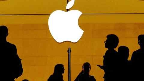 Customers go on the Apple logo inside the Apple store at Grand Central Station in New York