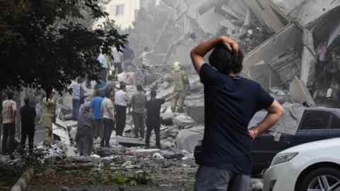 The person interacts with the width of residential buildings in Nobonese Square after Israeli air strikes in Tehran, Iran.
