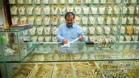 An Iranian merchant examines his bills in his golden store in Bazar