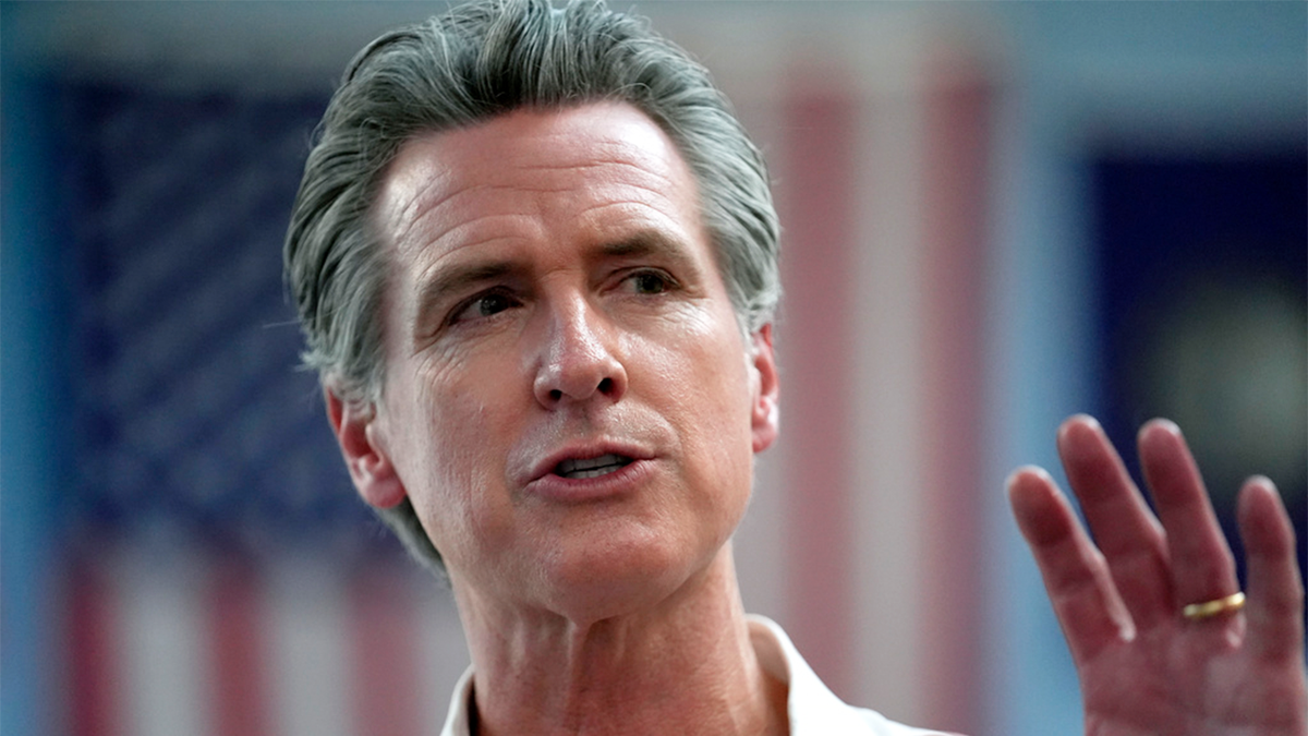 California Governor Gavin New Roosome with an American flag in the background
