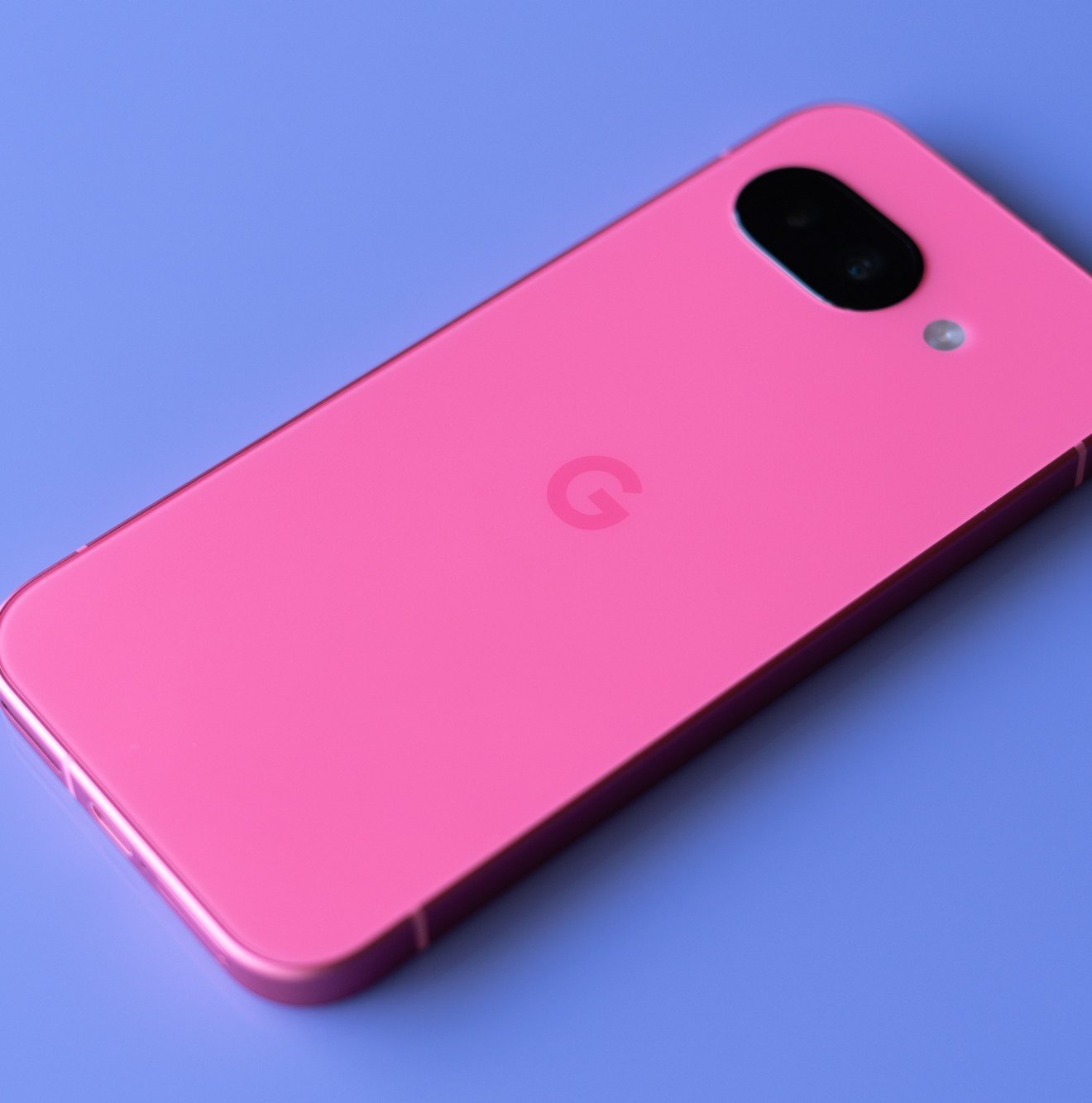 Google Pixel 9A in Peony Pink against a purple background.