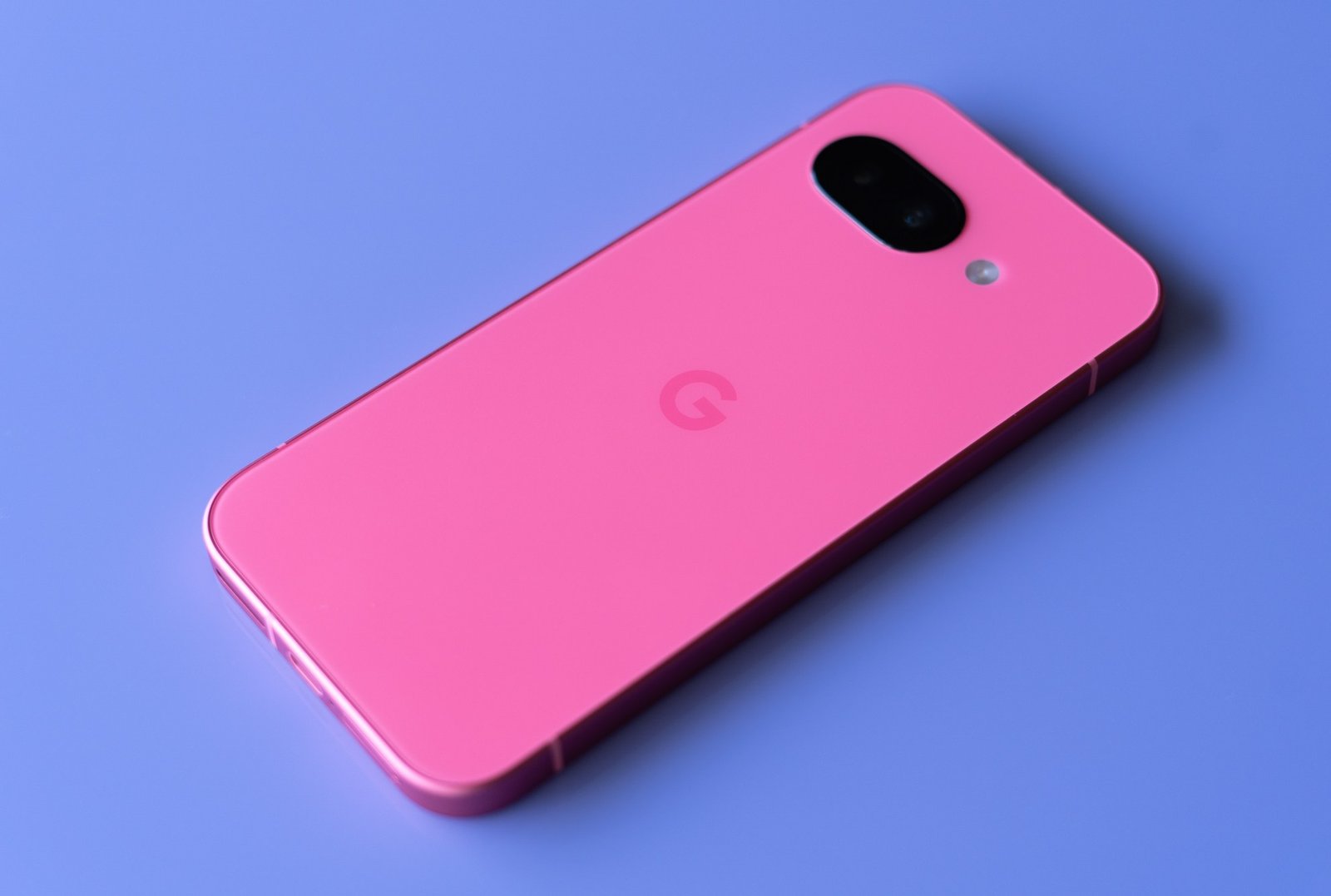 Google Pixel 9A in Peony Pink against a purple background.