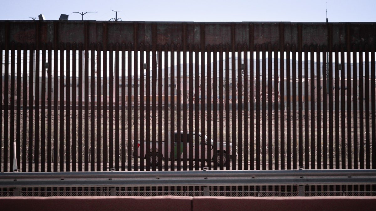 A truck seen through the border wall slices