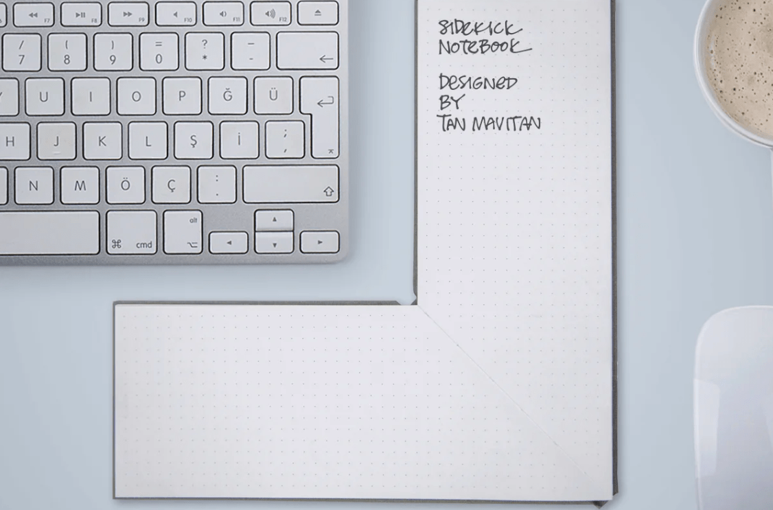 The keyboard with a L -shaped notebook next to Di and a pen below.