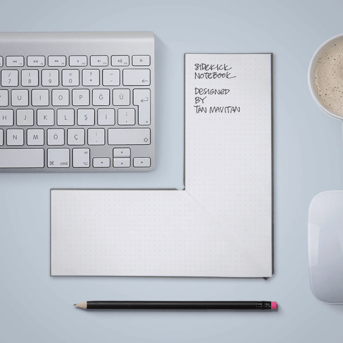 The keyboard with a L -shaped notebook next to Di and a pen below.