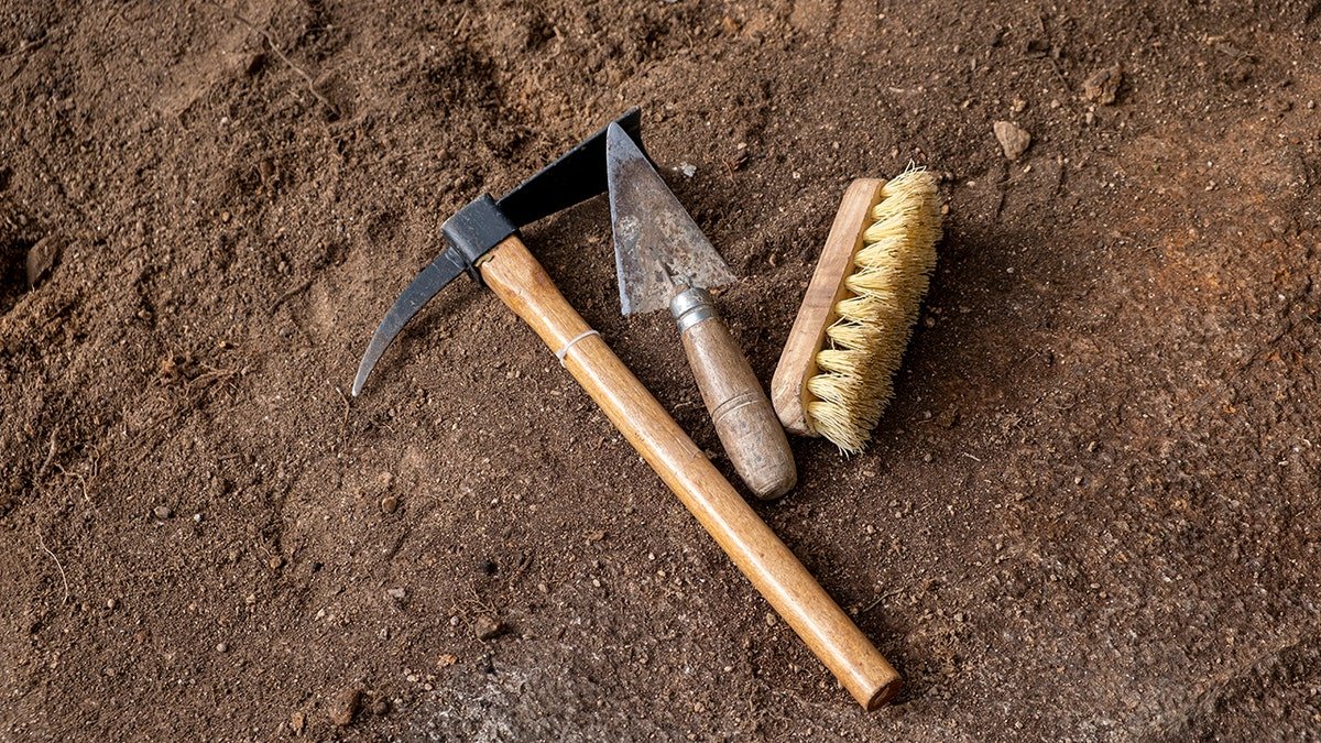 Pickaxe, shovel and brush. Tools in archaeological excavation