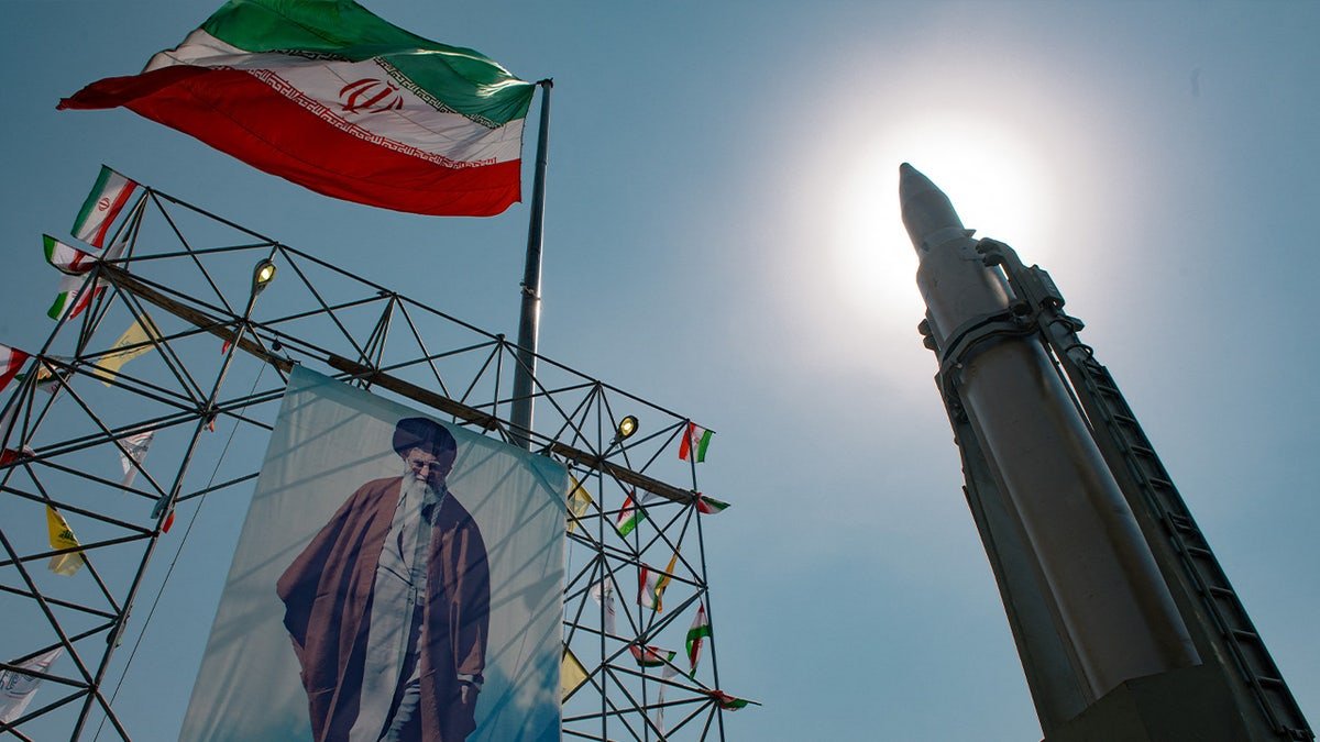 Iran's ballistic missile stands next to the image of Iran's leader, Ayatollah Ali Khameneini.