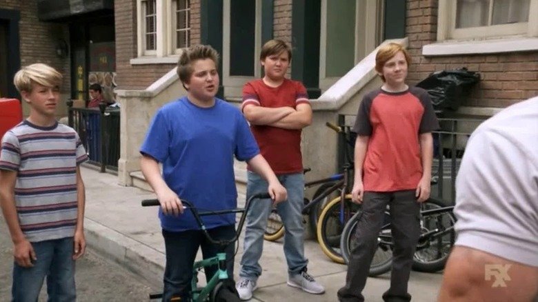 A group of children fill Mac and Charlie outside the screen as always sunny in Philadelphia