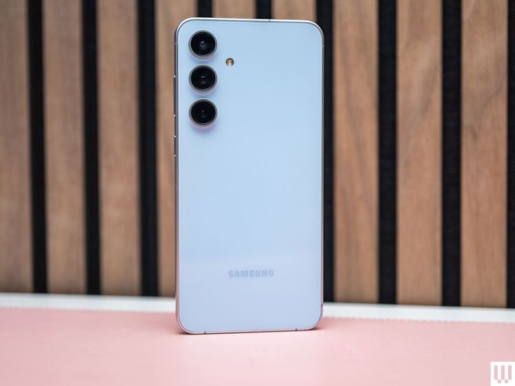 Back side of the Samsung Galaxy S24 FE, a slim white phone with 3 camera lenses