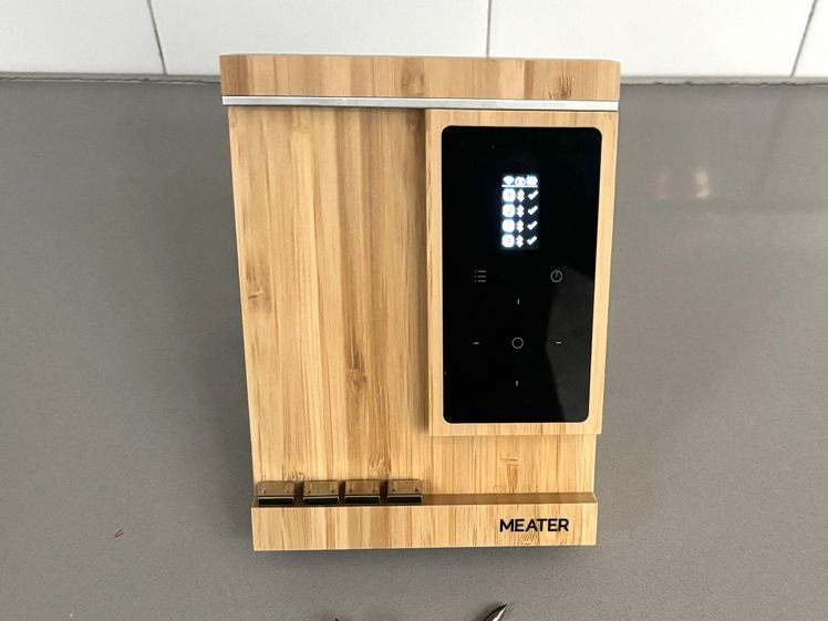 Meater Pro XL, a wooden panel with a small screen in front of silver rod meat thermometers