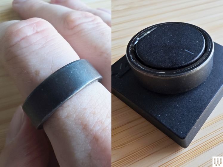 The Ultrahuman Ring Air, a black smart ring, resting on the charger beside an image of it worn on a person's finger
