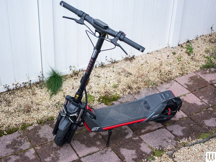 Segway ZT3 Pro, a black and red electric scooter in front of a white fance