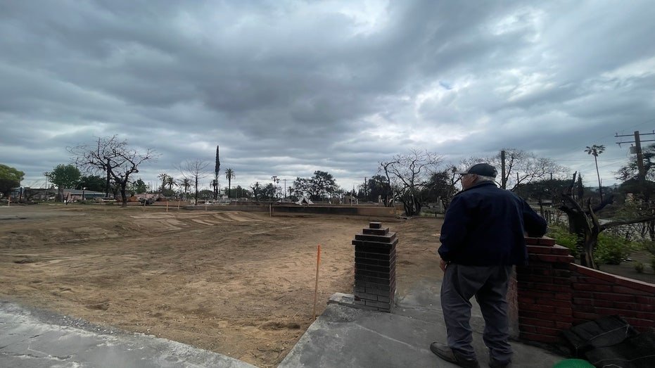 A man looked at a paved land where his house was once stood up