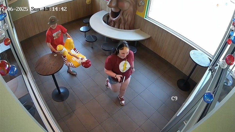 The suspect carries the statue of Ronald McDonald during the theft of McDonald's Restaurant