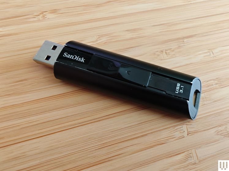 Black USB stick with the cap off, sitting on wooden surface 