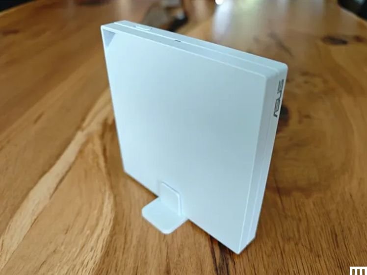 Side view of slim white wifi router device sitting on long wooden table