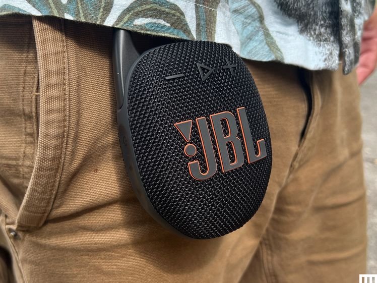 J.B.L. Clip 5, a small round and circular speaker clipped to the waistband of a person's pants