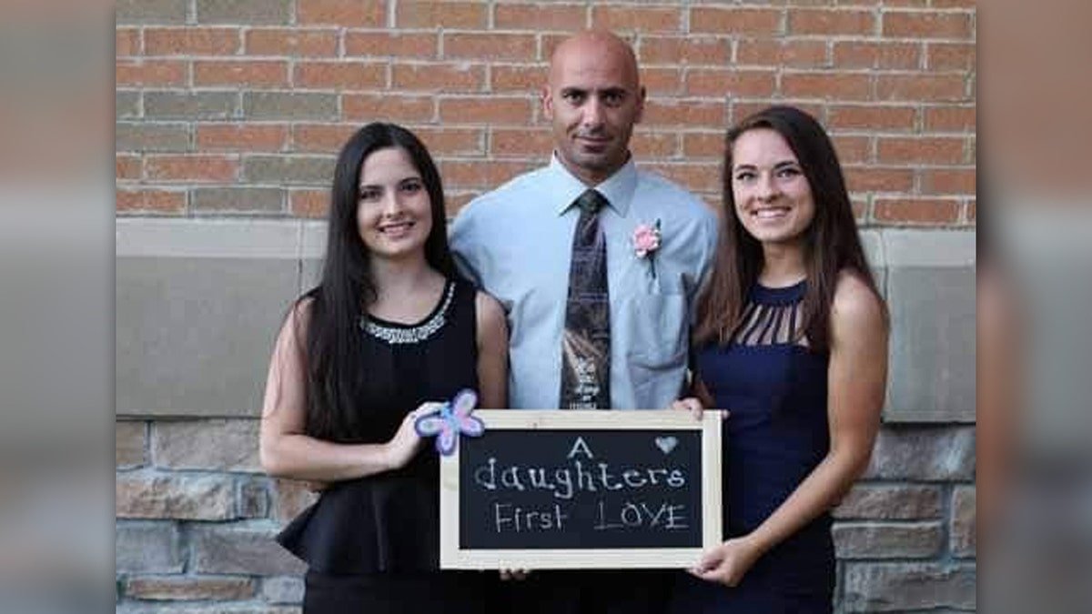 Comparatore and girls carry a banner calling their father "First love"