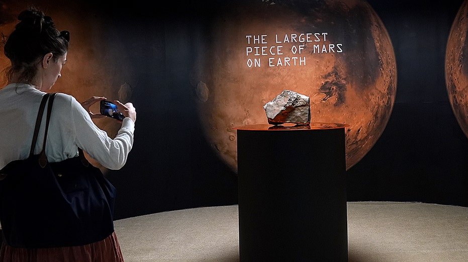The person takes a picture of Mars
