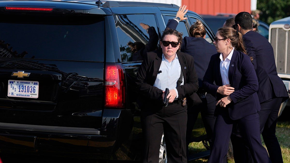 The secret service agents surround the Trump vehicle