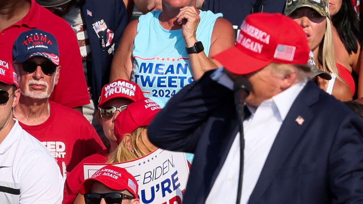 Donald Trump interacts with multiple shots during a campaign gathering