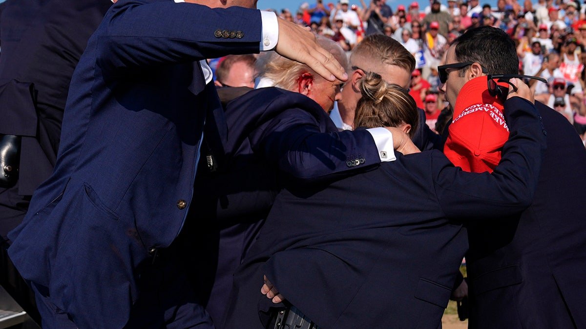 Donald Trump surrounds American secret services agents in a campaign gathering